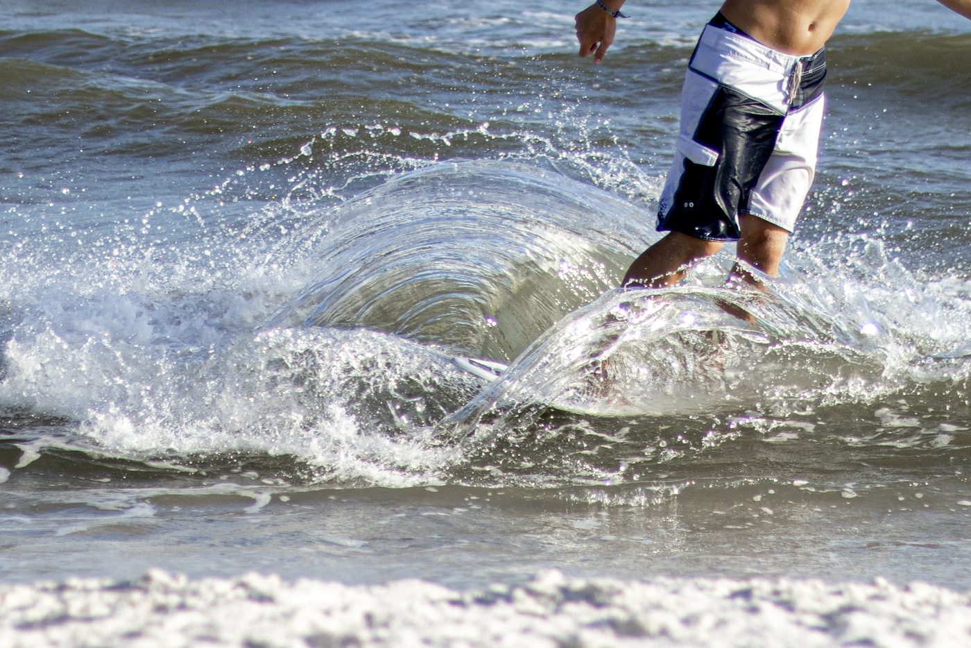 A surfer carving through a breaking wave.